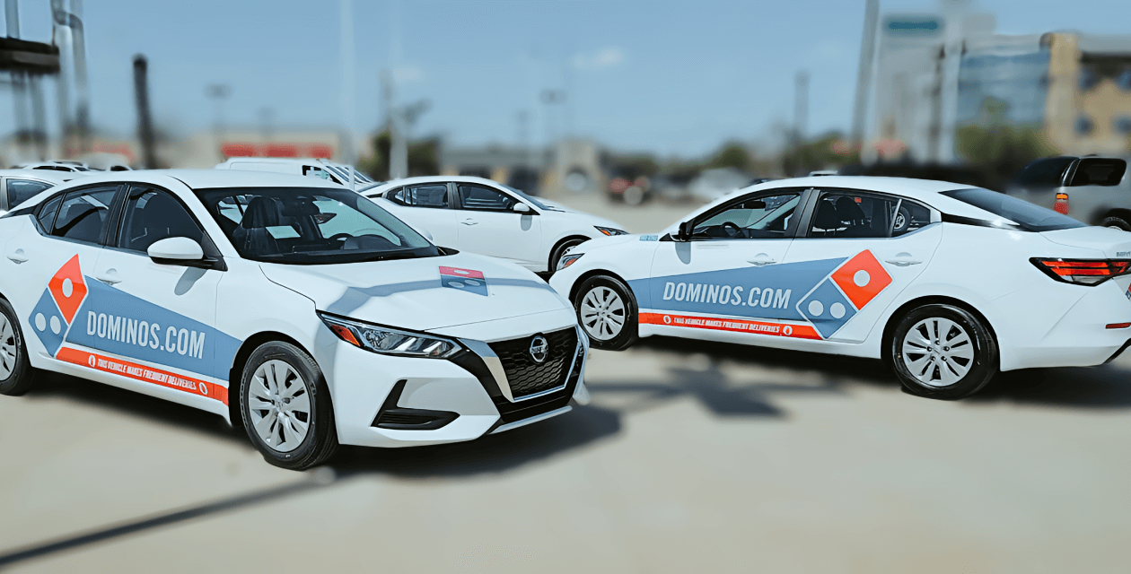 An image of cars wrapped with the dominoes logo
